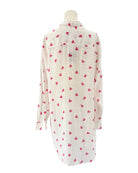 White shirt dress with pink heart patterns on a white background