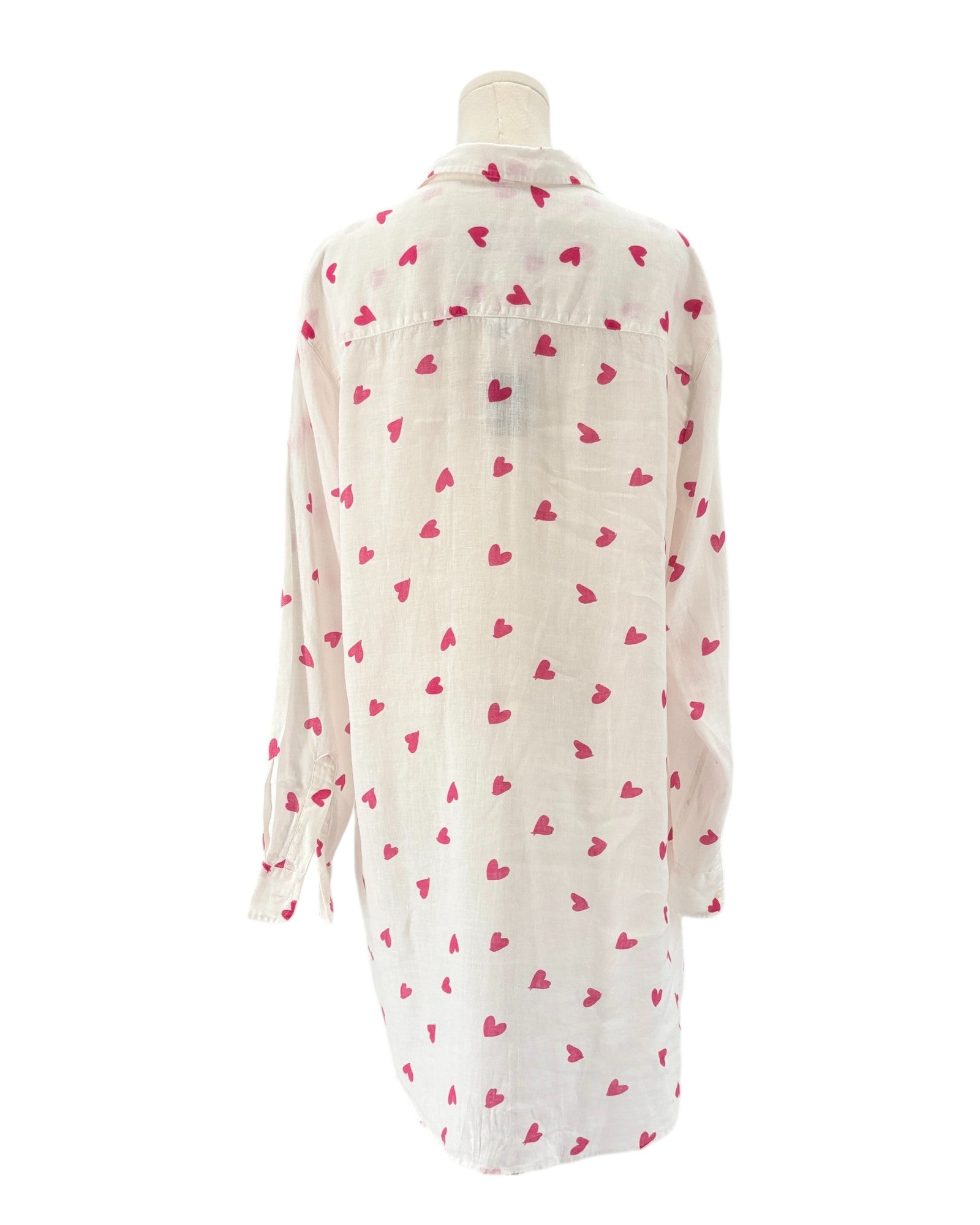 White shirt dress with pink heart patterns on a white background