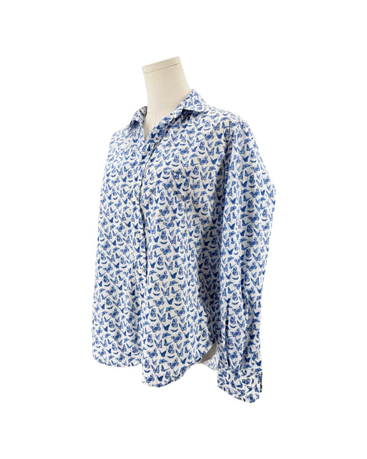 A long-sleeve button-up shirt with an all-over blue and white butterfly pattern, displayed on a cream-colored mannequin torso against a plain white background.