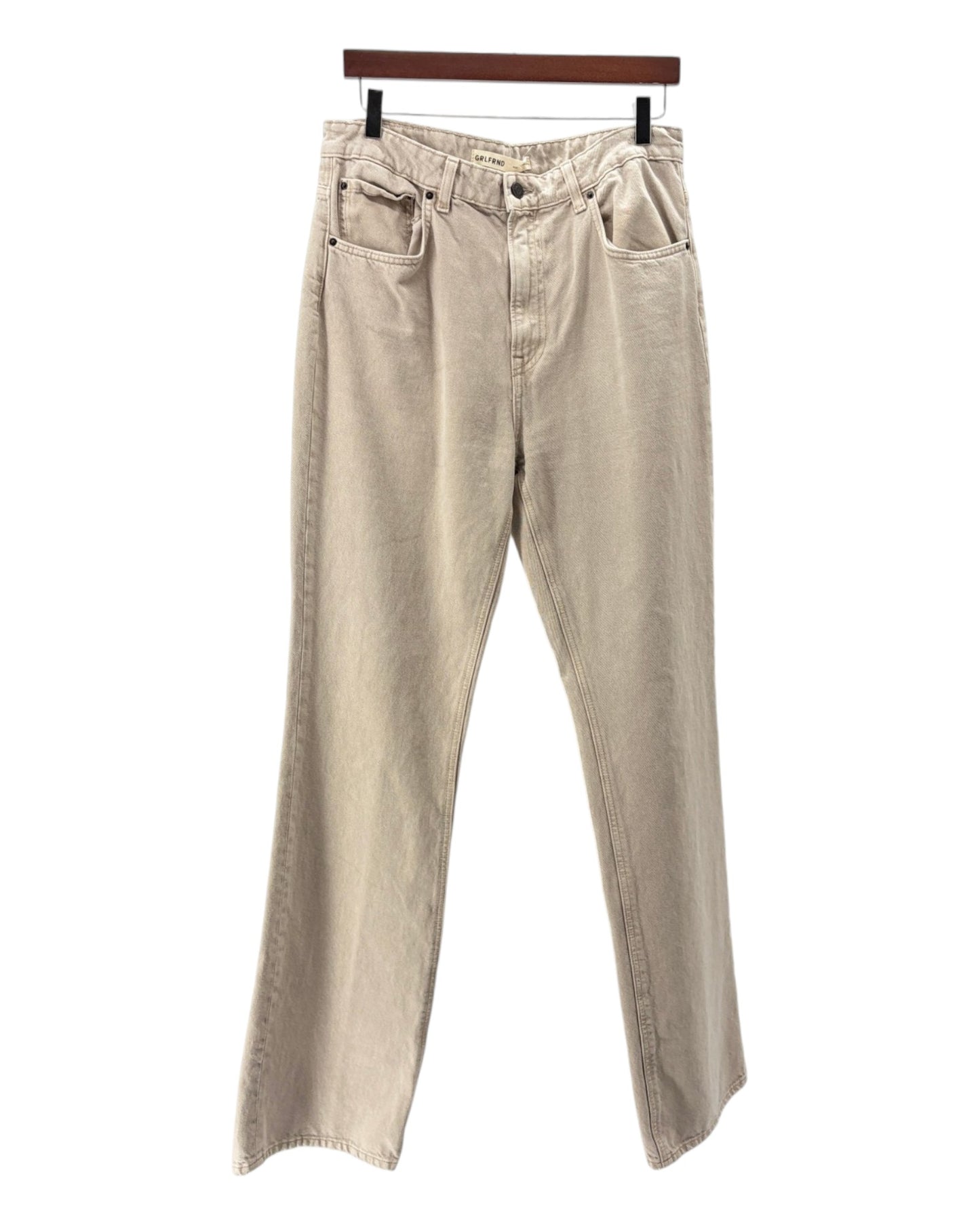 Beige pants on a hanger against a white background