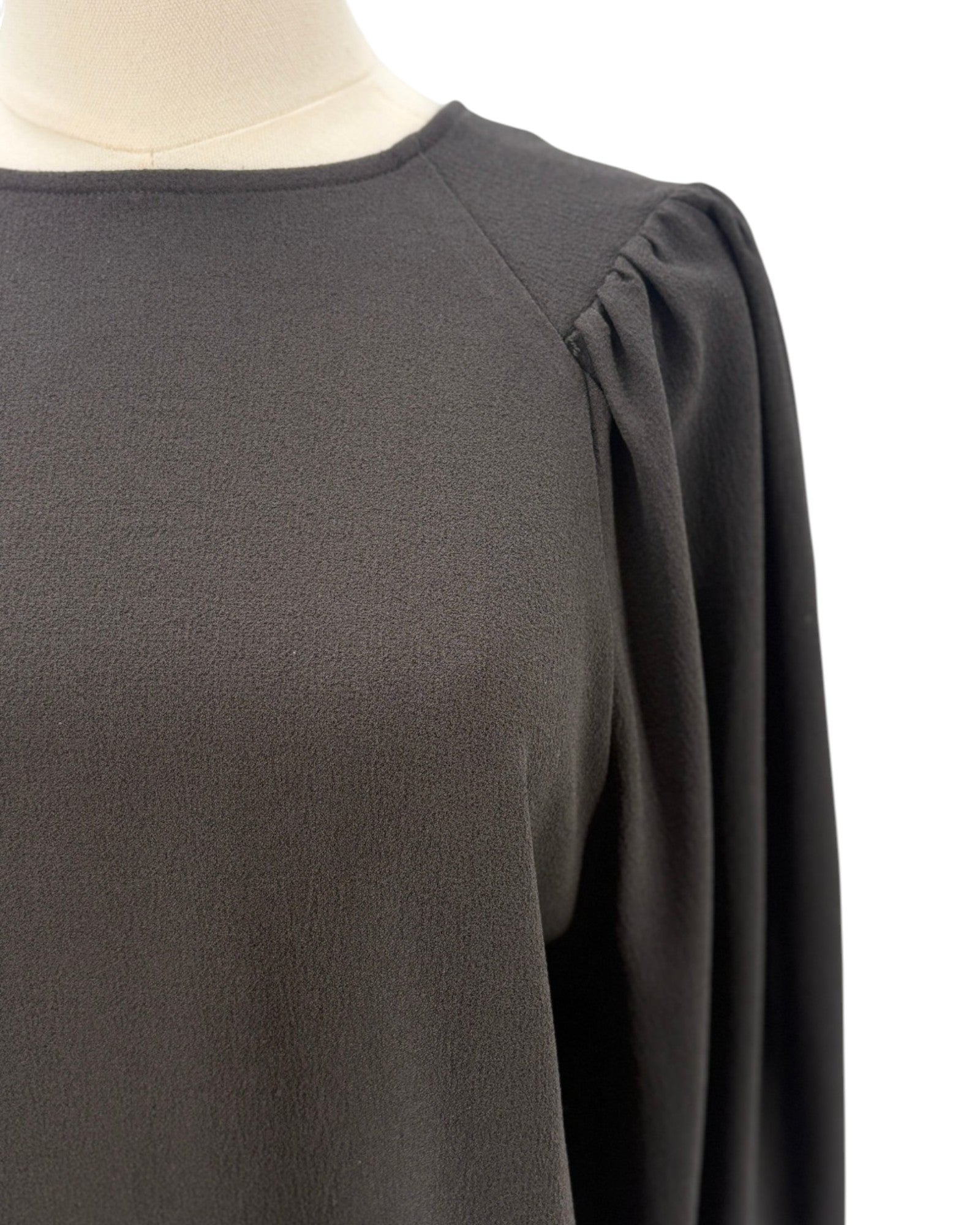 Ganni black blouse on a mannequin with a white background