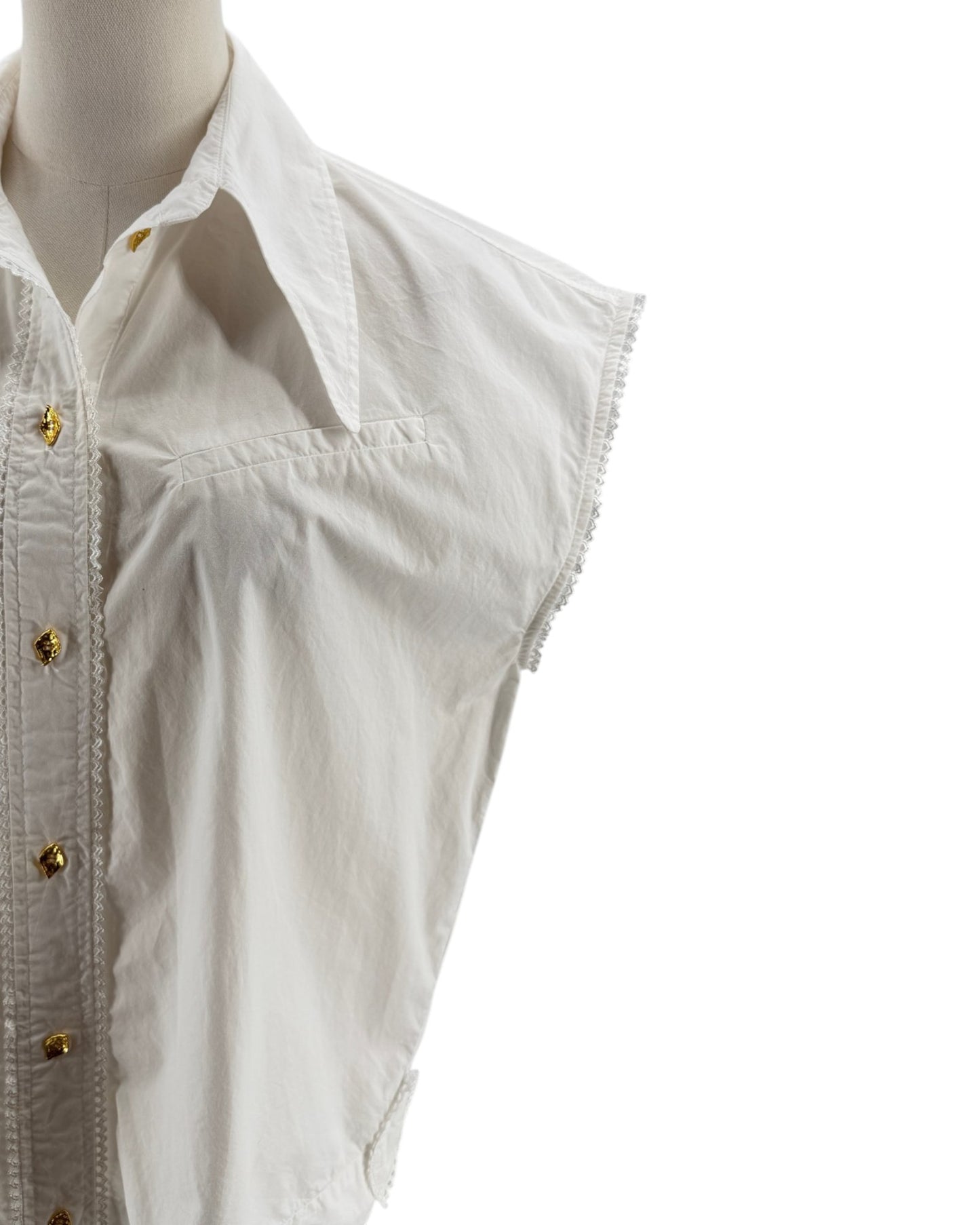 White sleeveless shirt on a mannequin with gold buttons against a white background
