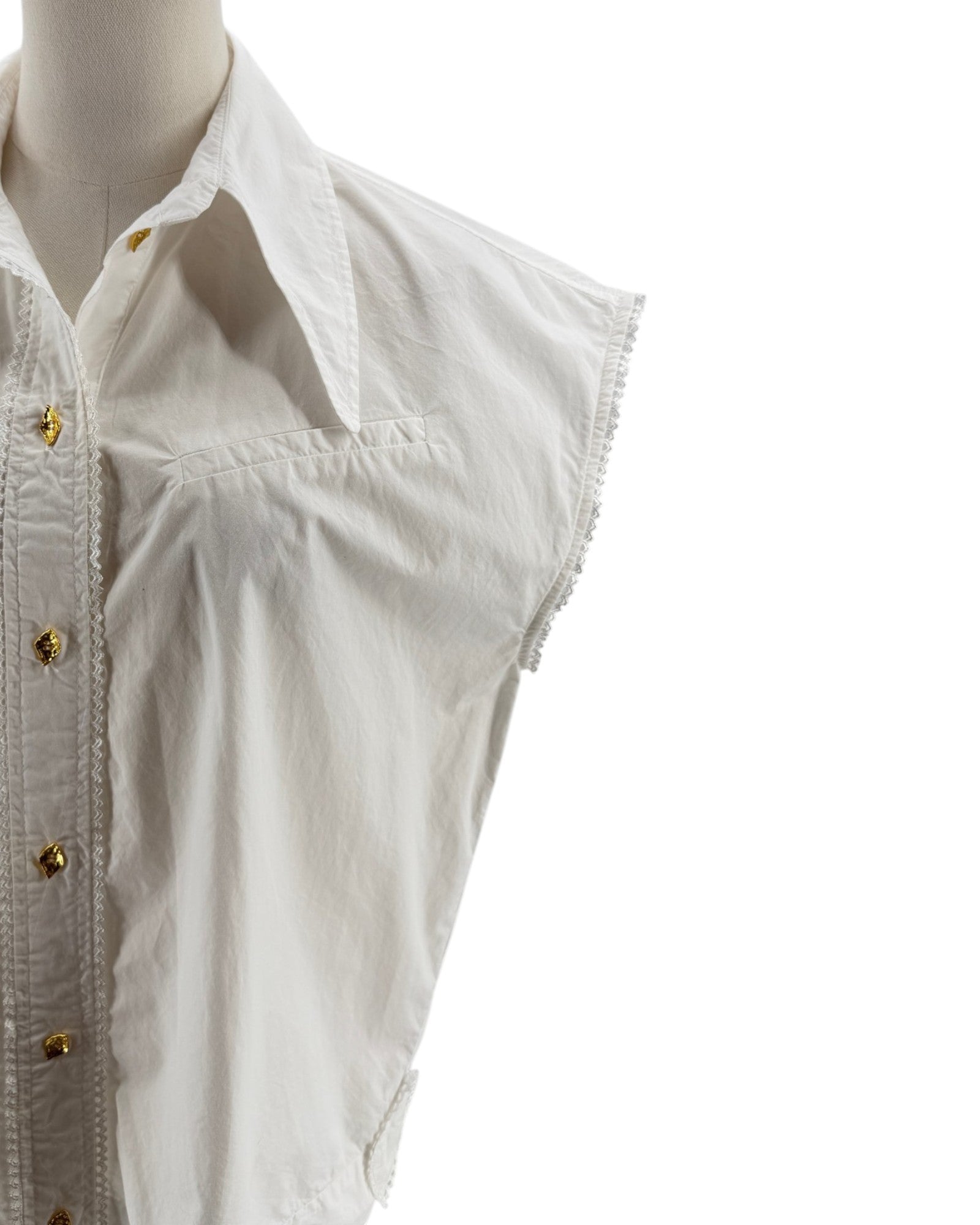 White sleeveless shirt on a mannequin with gold buttons against a white background