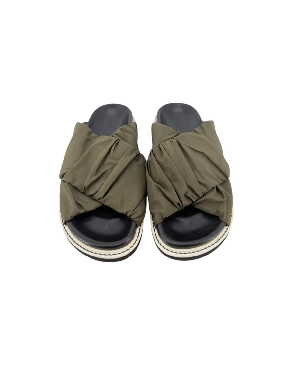 Black slip on sandals with two thick green straps across the top on a white background