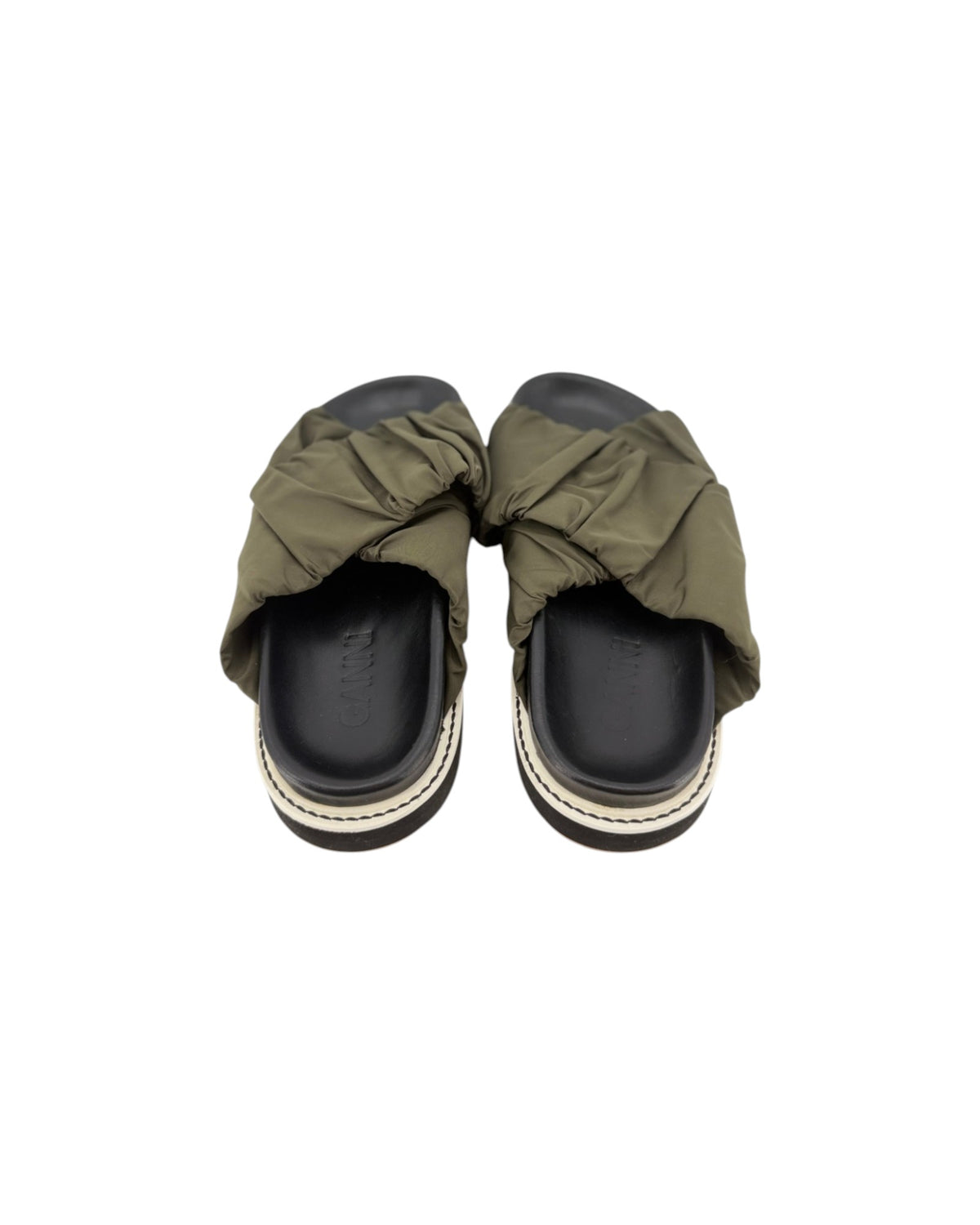 Black slip on sandals with two thick green straps across the top on a white background