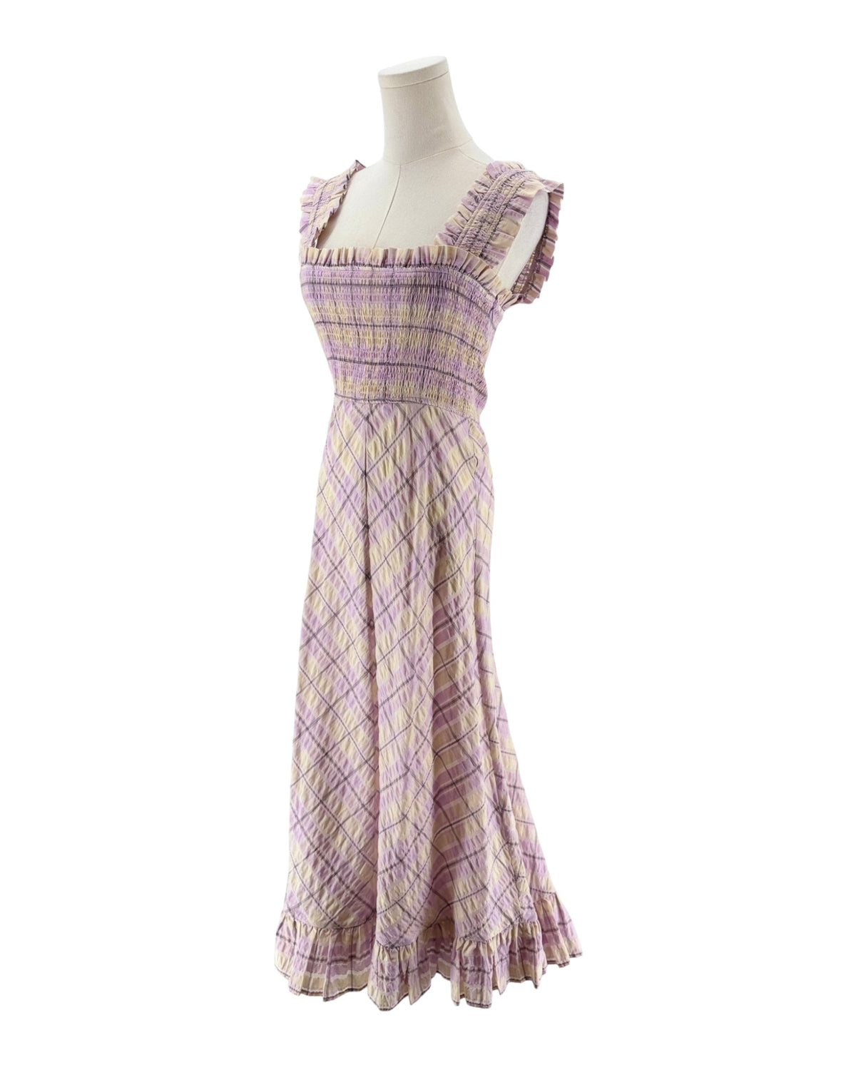 A sleeveless, smocked maxi dress with a purple and beige plaid pattern, displayed on a mannequin against a white background.