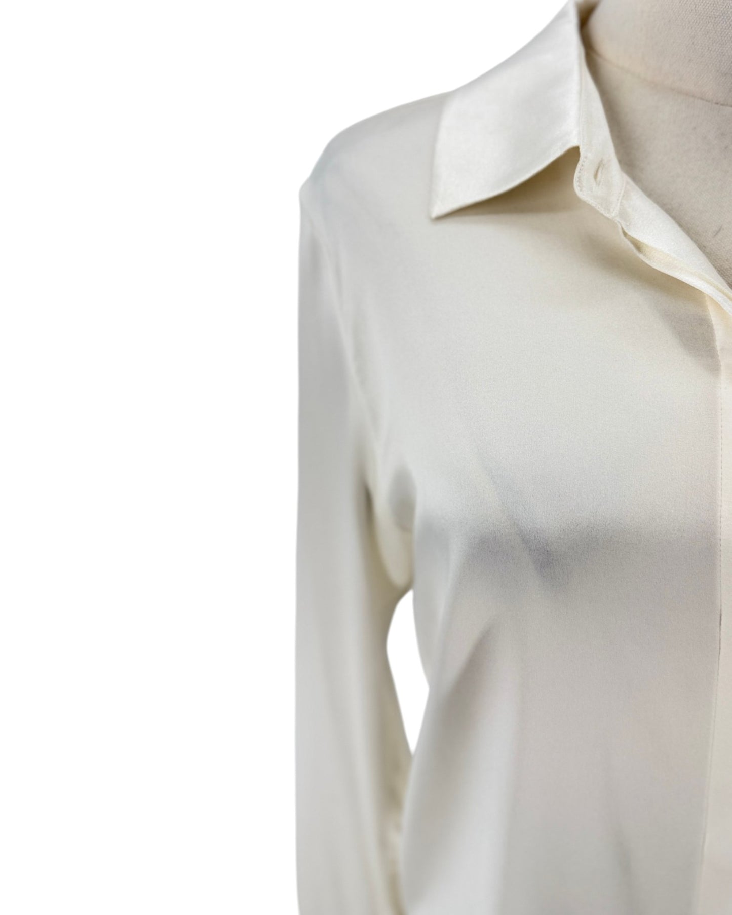 A close-up of a cream-colored long-sleeve button-up shirt on a mannequin torso, showing the collar and upper chest against a plain white background.