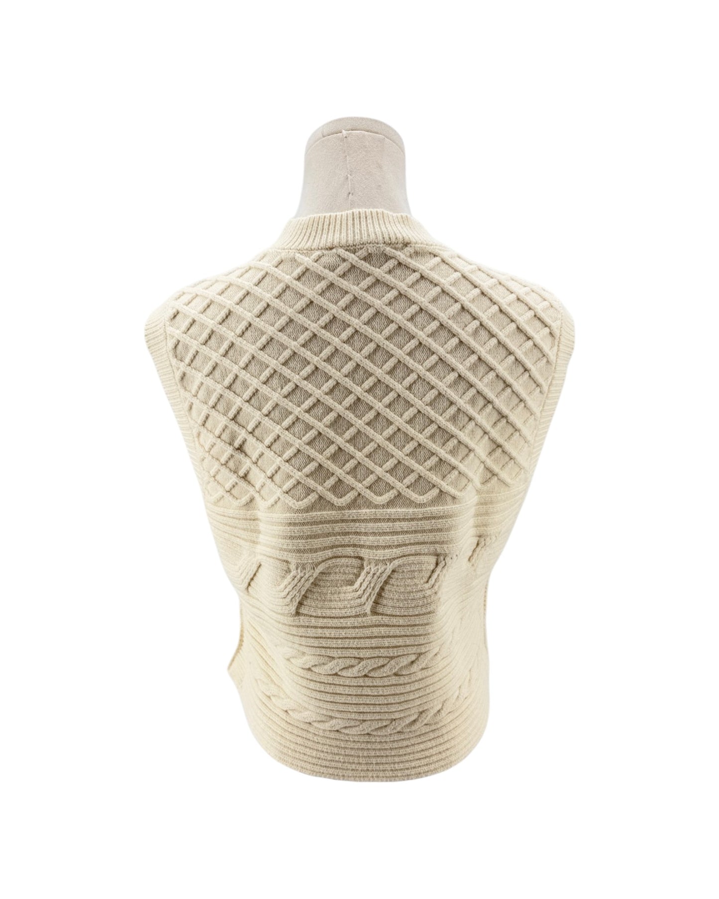 A cream-colored cable-knit sweater displayed on a mannequin torso, showing the back view with a diamond lattice pattern and textured knit details.
