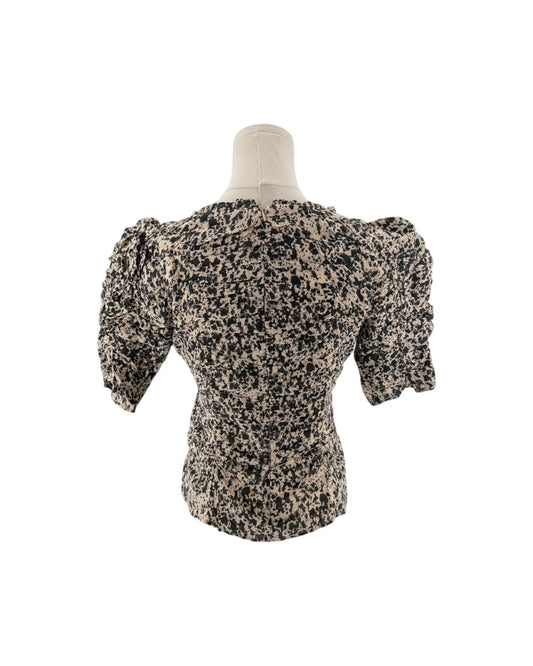 A short-sleeved puff-silhouette blouse with a black and beige speckled pattern, displayed on a mannequin torso against a white background.