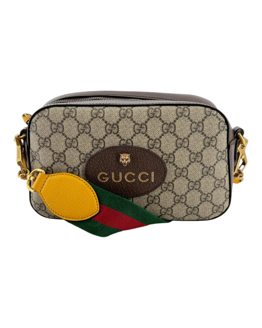 Small leather double G gucci handbag with a yellow zipper tassel, red and green strap, and with small all over double g print on a white background