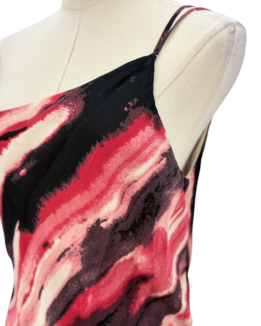 Mannequin wearing a red and black abstract patterned dress on a white background