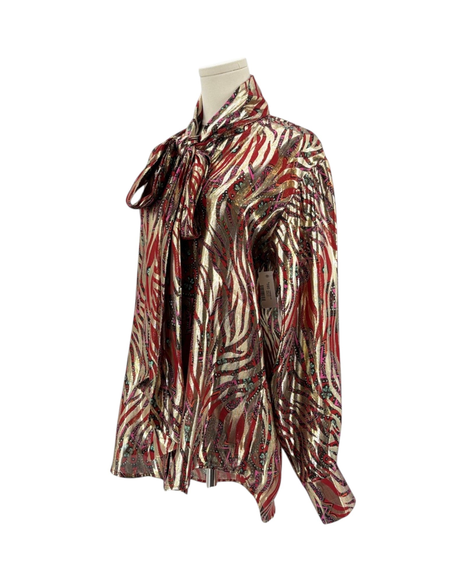 A long-sleeve blouse with an abstract zebra-like pattern in red, brown, black, and beige, featuring a tie-neck detail, displayed on a mannequin torso against a white background.