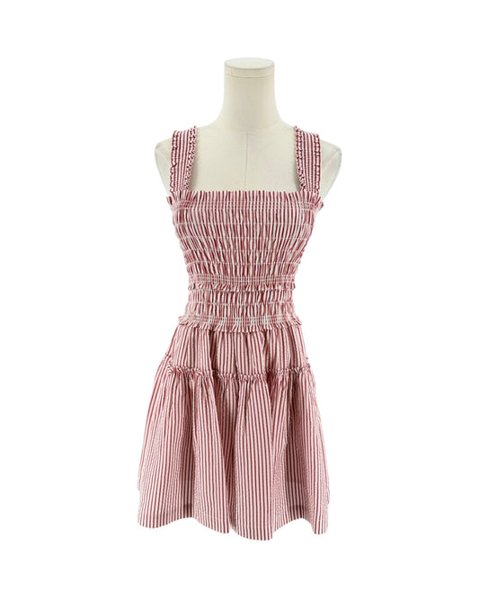 A sleeveless smocked dress with tie shoulder straps, featuring a striped red and white print on a white background, displayed on a mannequin torso against a white background.
