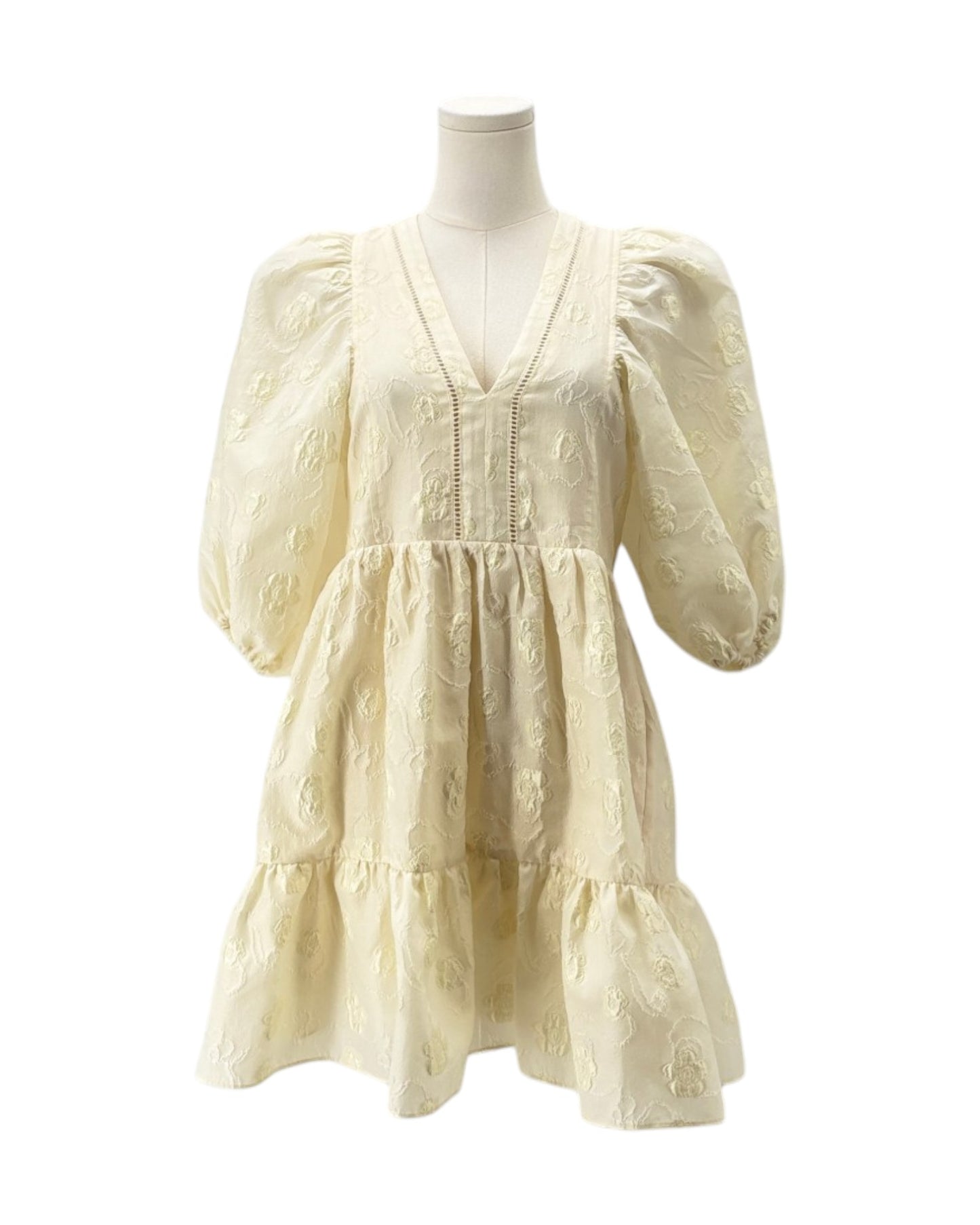 Cream-colored dress on a mannequin against a white background