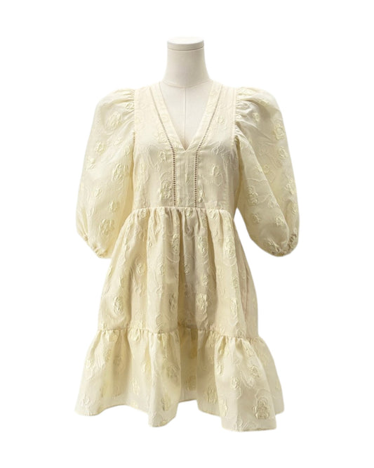 Cream-colored dress on a mannequin against a white background