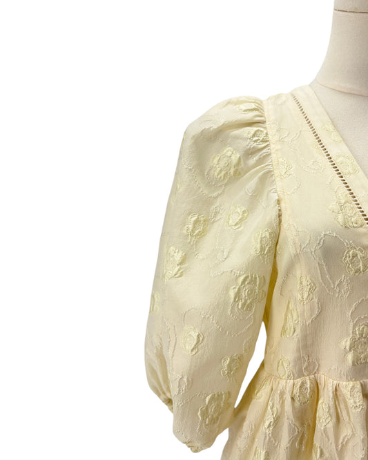 Light yellow lace dress on a mannequin with a white background