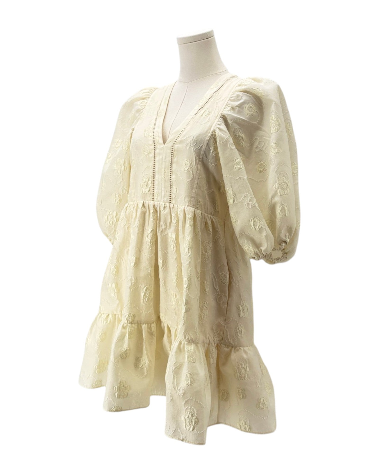 Cream-colored dress on a mannequin against a white background