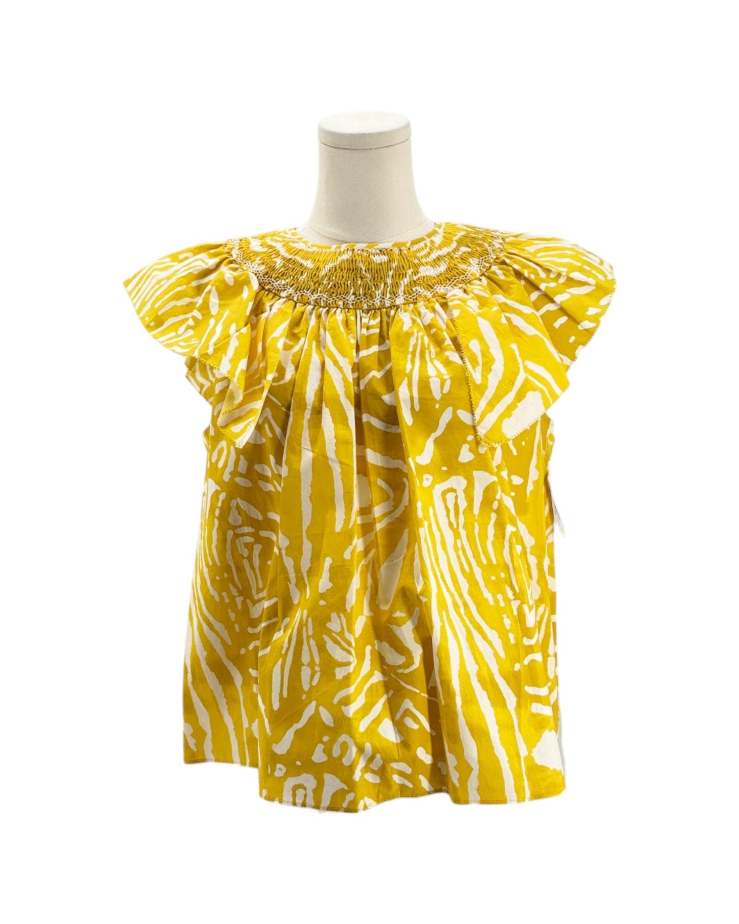 Yellow patterned top on a mannequin against a white background