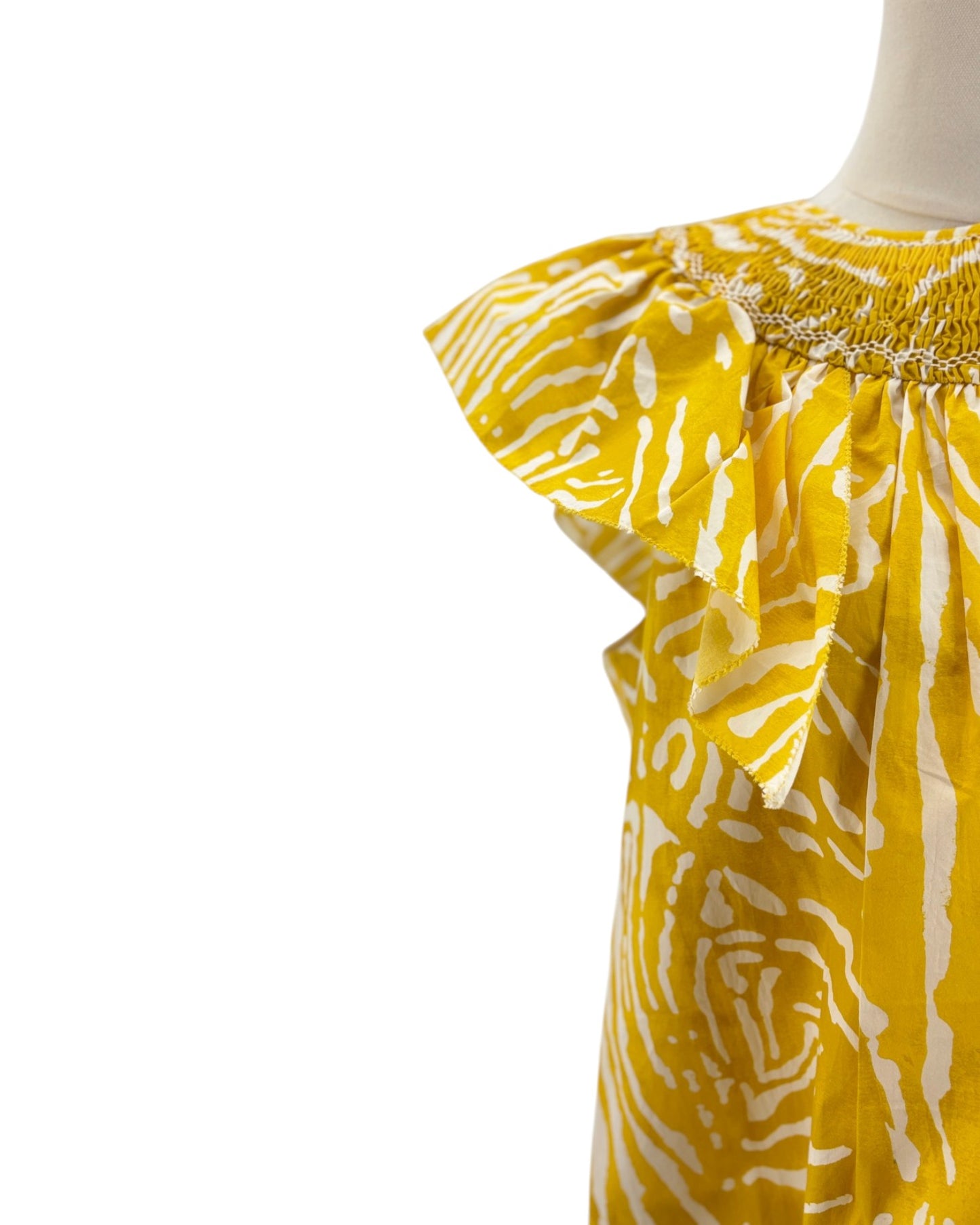 Yellow and white patterned dress on a mannequin against a white background