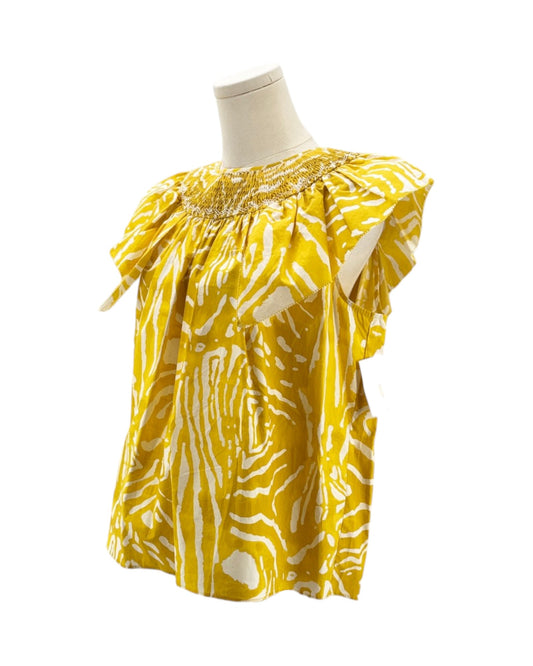 Yellow patterned blouse on a mannequin against a white background
