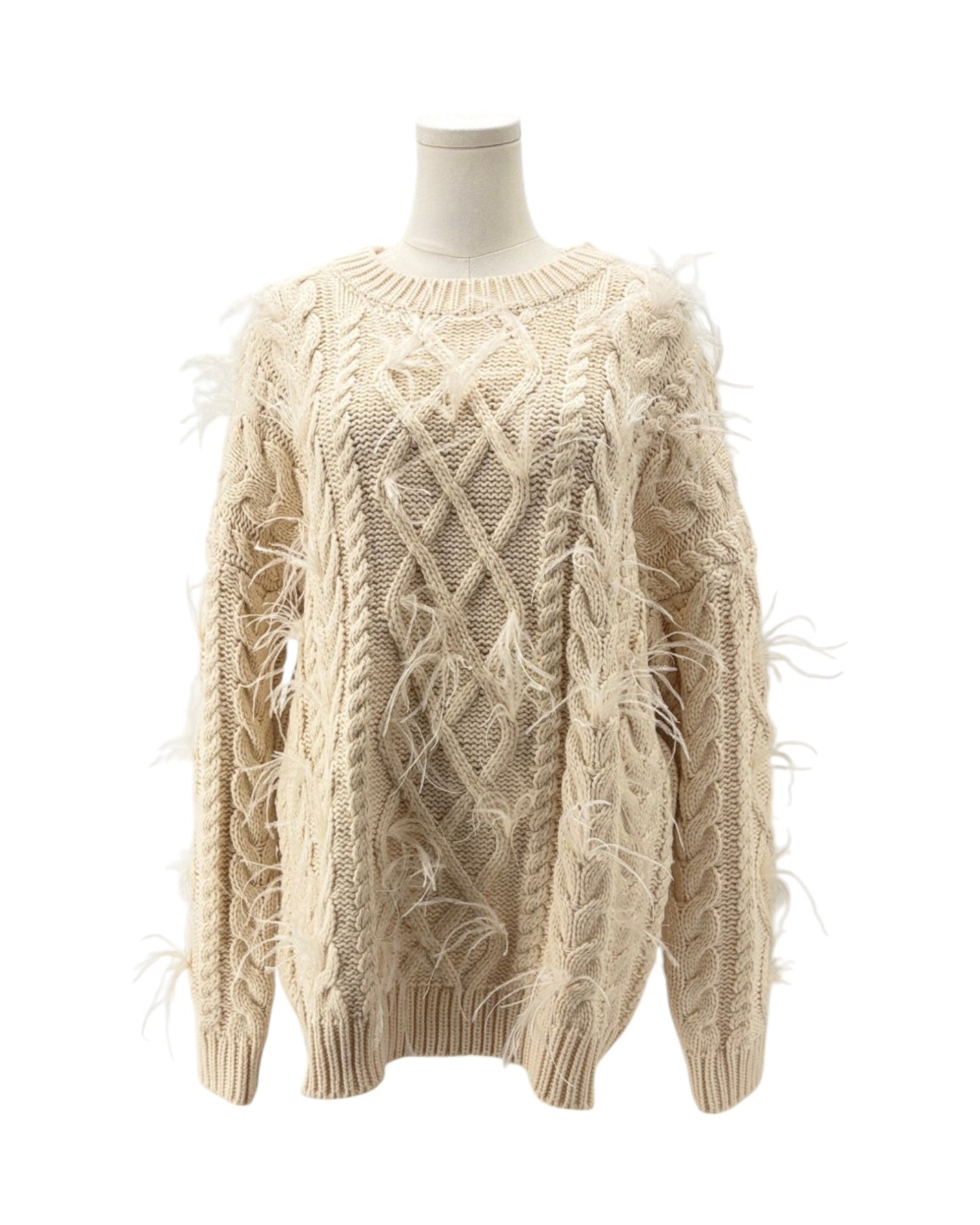 Beige cable knit sweater on a mannequin against a white background