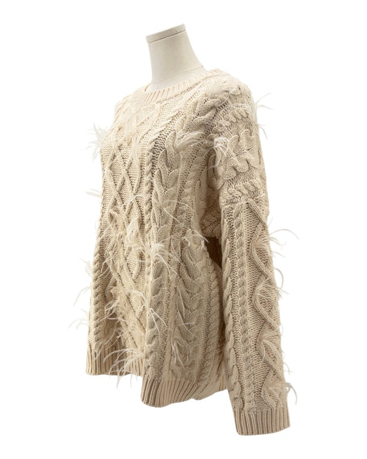 Beige cable knit sweater on a mannequin against a white background