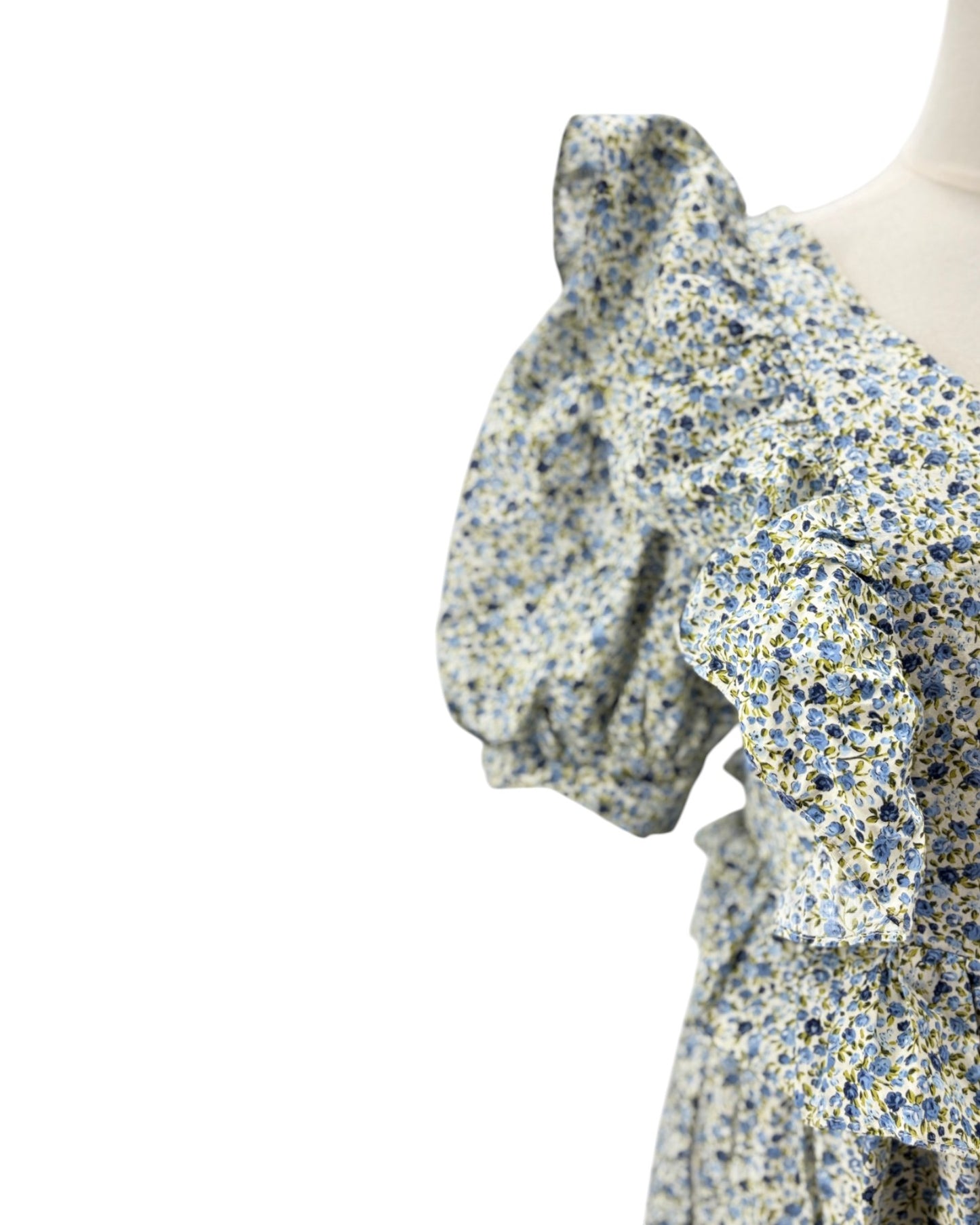 Floral dress with ruffled sleeves on a mannequin against a white background