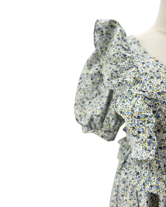 Floral dress with ruffled sleeves on a mannequin against a white background