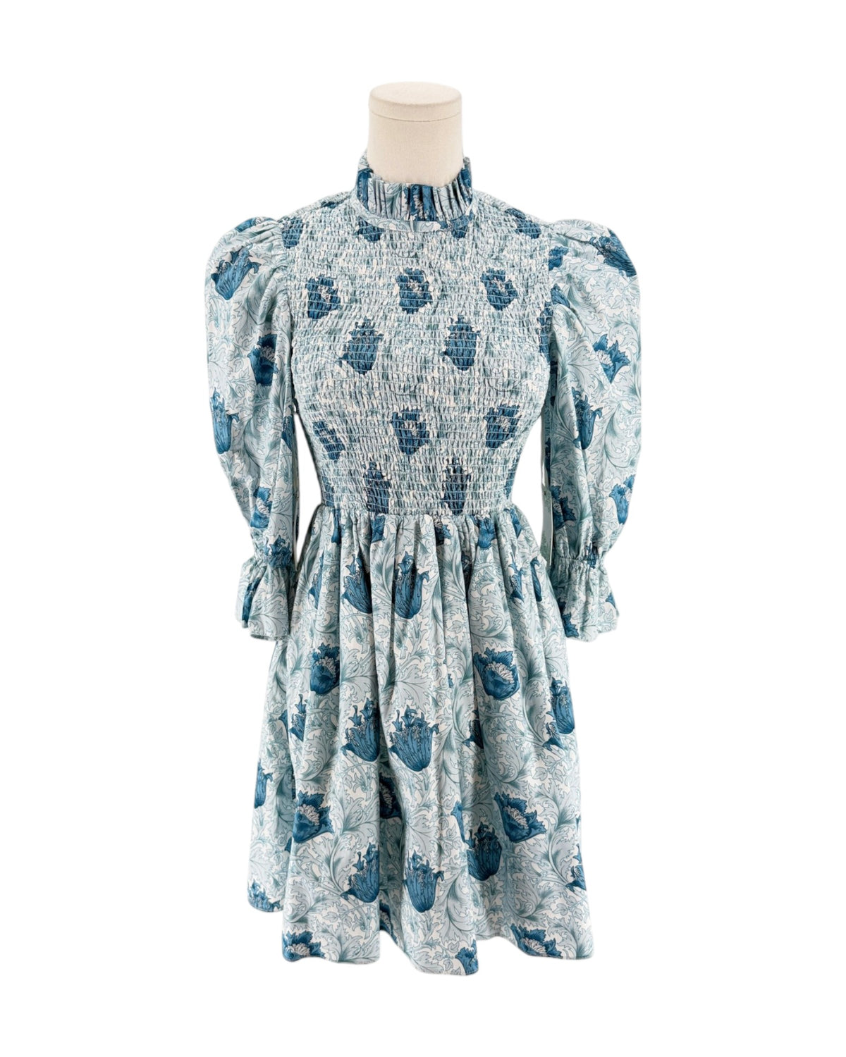Blue floral mini dress with smocking on a mannequin on a white background