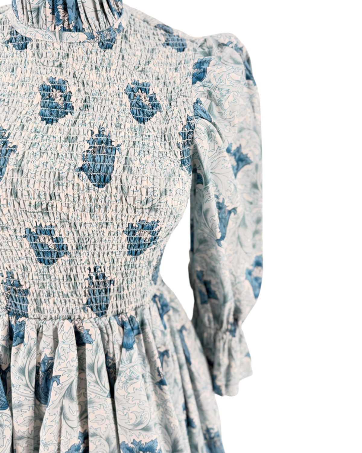 Blue floral mini dress with smocking on a mannequin on a white background
