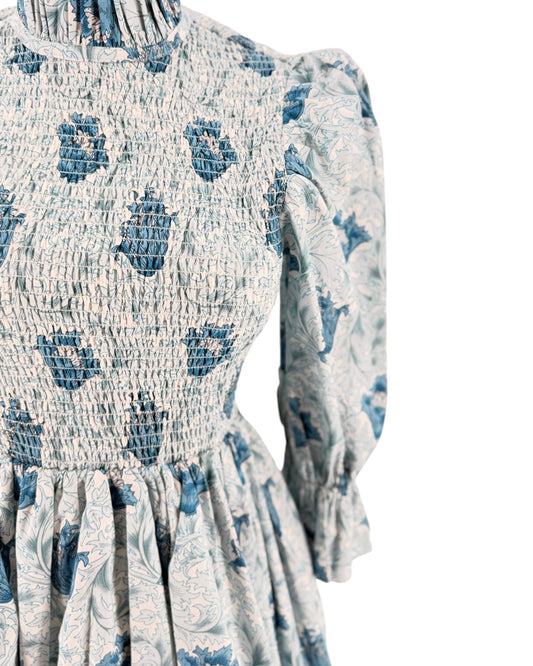 Blue floral mini dress with smocking on a mannequin on a white background