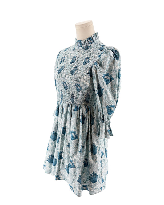 Blue floral mini dress with smocking on a mannequin on a white background