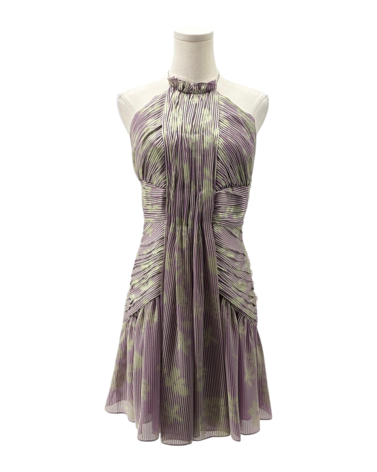 Purple and green patterned dress on a mannequin against a white background