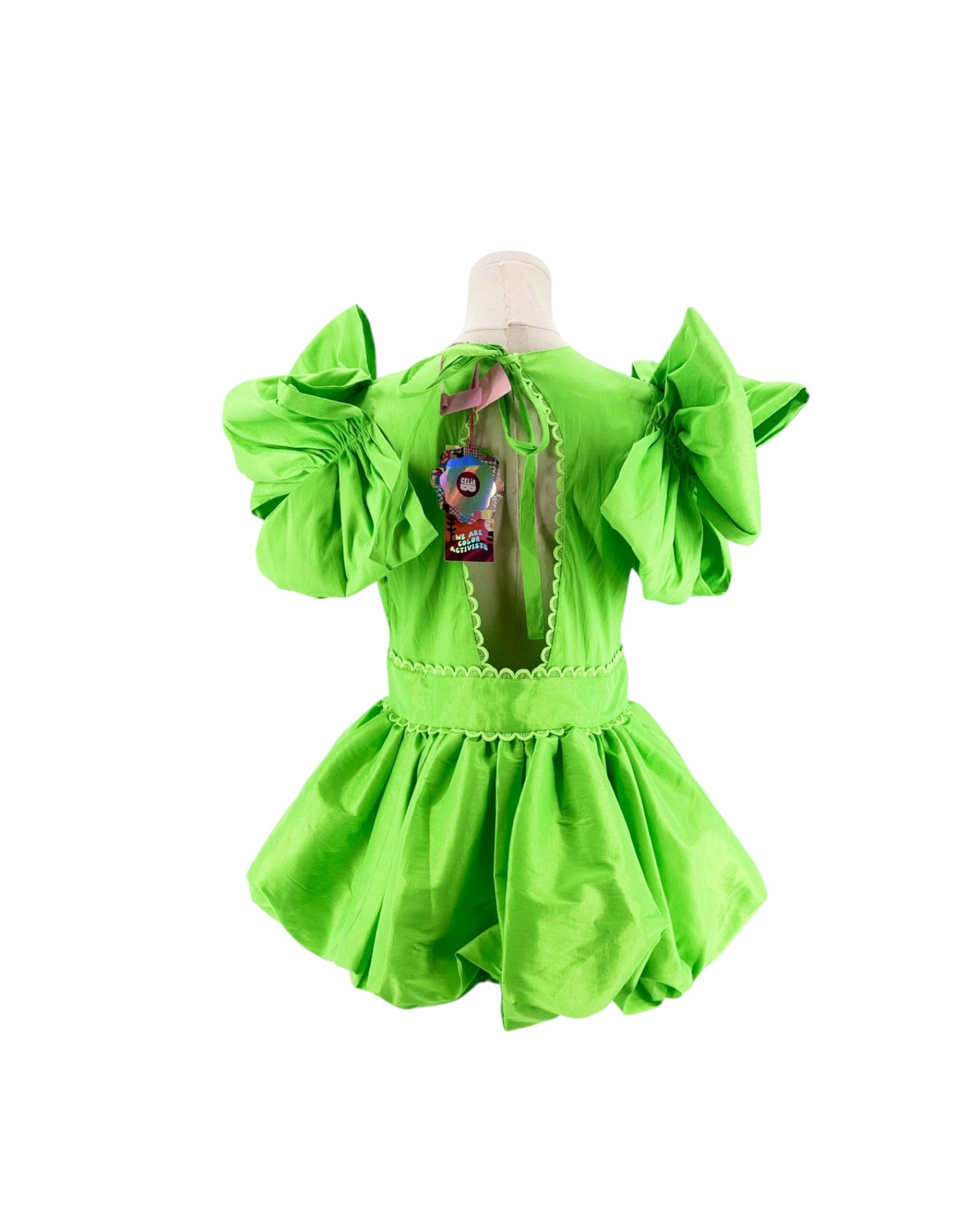 A bright lime green costume dress displayed on a mannequin from the back, featuring voluminous ruffled sleeves, a scalloped open back, and a flared skirt.