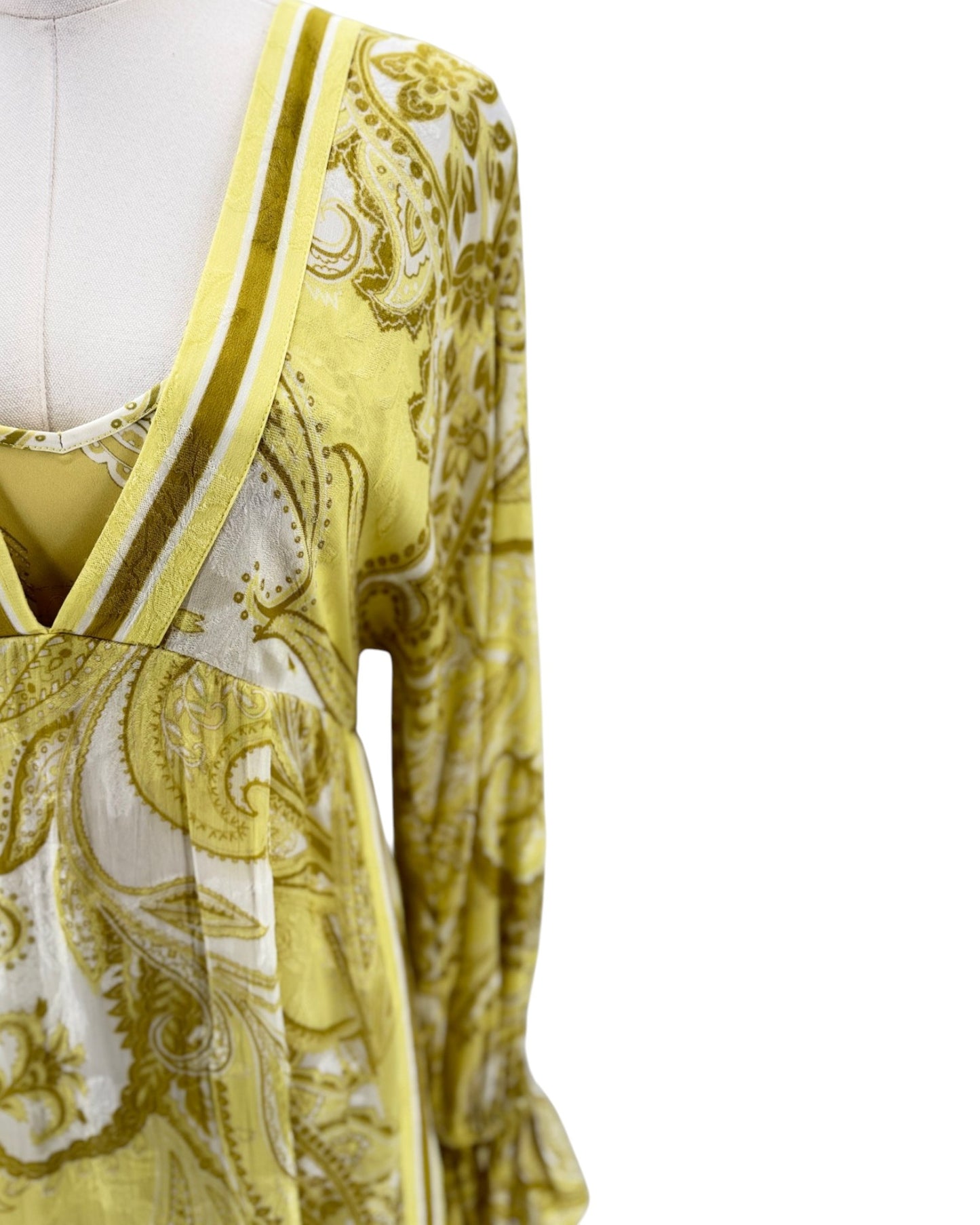 Yellow and white patterned dress on a mannequin against a white background