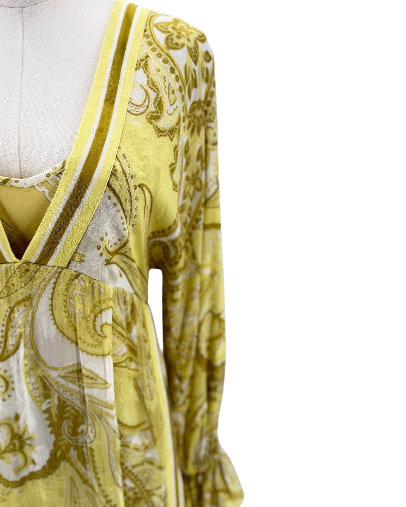 Yellow and white patterned dress on a mannequin against a white background