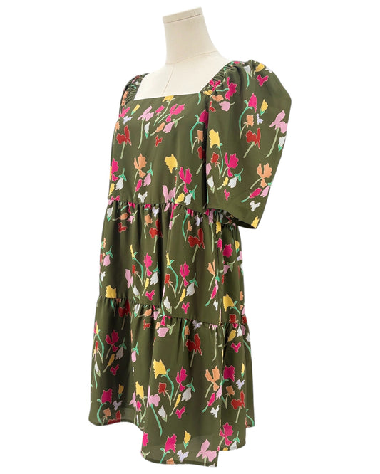 Green dress with colorful floral pattern on a mannequin against a white background