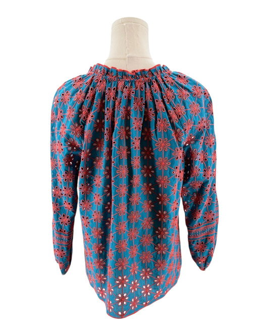 Blue blouse with red floral pattern on a mannequin against a white background
