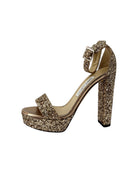 Gold glitter high-heeled sandal on a white background