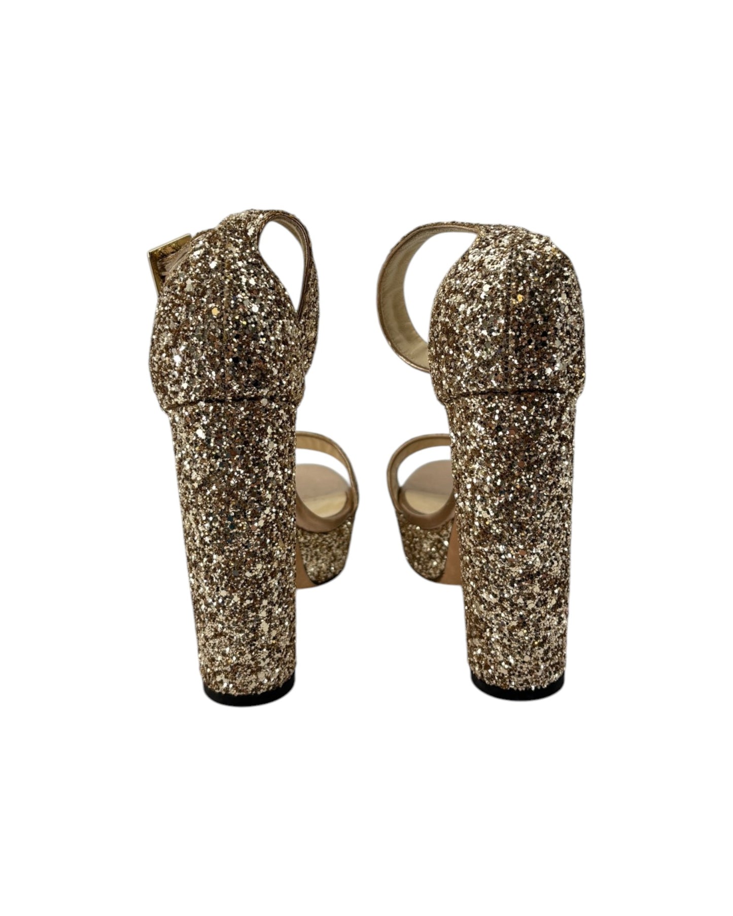Gold glittery high-heeled shoes on a white background