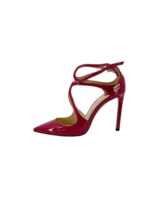 A single glossy patent leather high-heeled pump in a deep magenta-red color, featuring a pointed toe, criss-cross ankle straps, and a slim stiletto heel, shown against a plain white background.