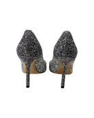 Pair of glittery high-heeled shoes on a white background