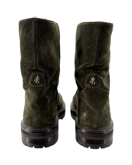 Pair of green suede boots with a brand logo on a white background