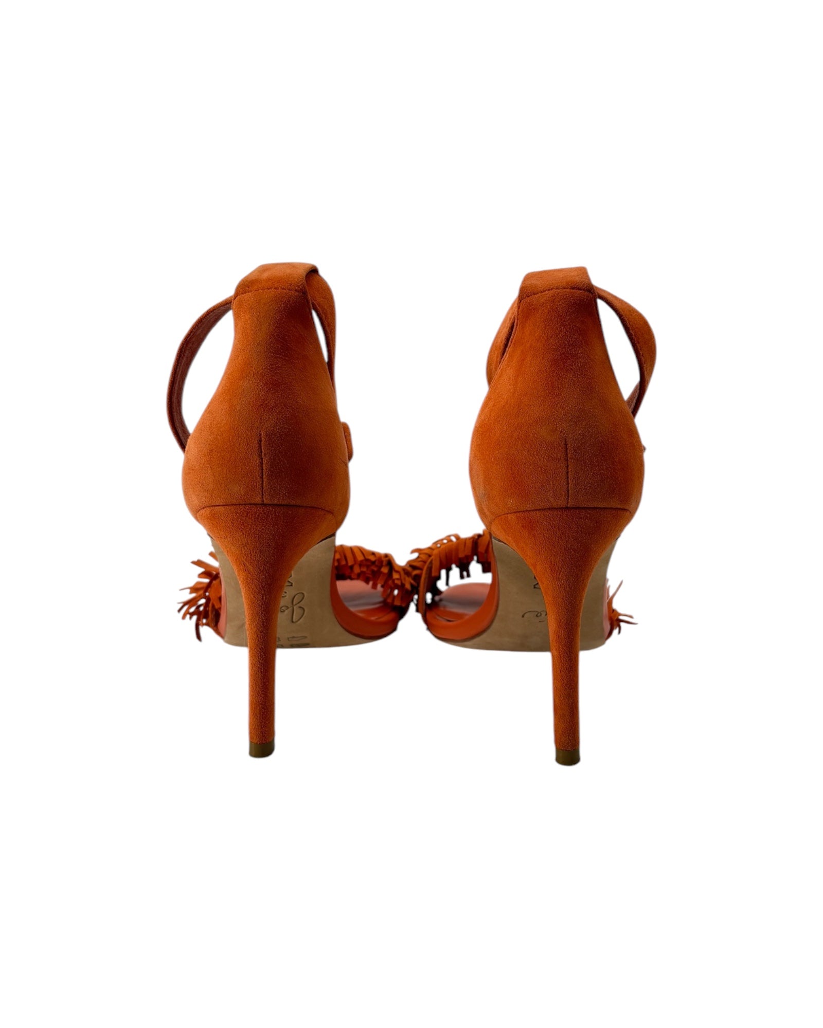 Pair of orange high-heeled shoes with fringe details on a white background