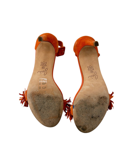 Orange sandals with tassels on a white background