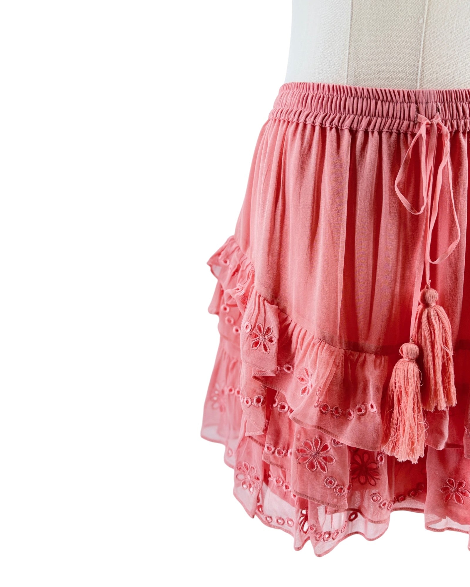 Pink skirt with tassels on a mannequin against a white background