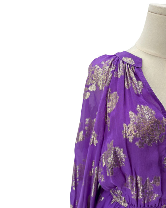 Purple dress with gold floral pattern on a mannequin against a white background