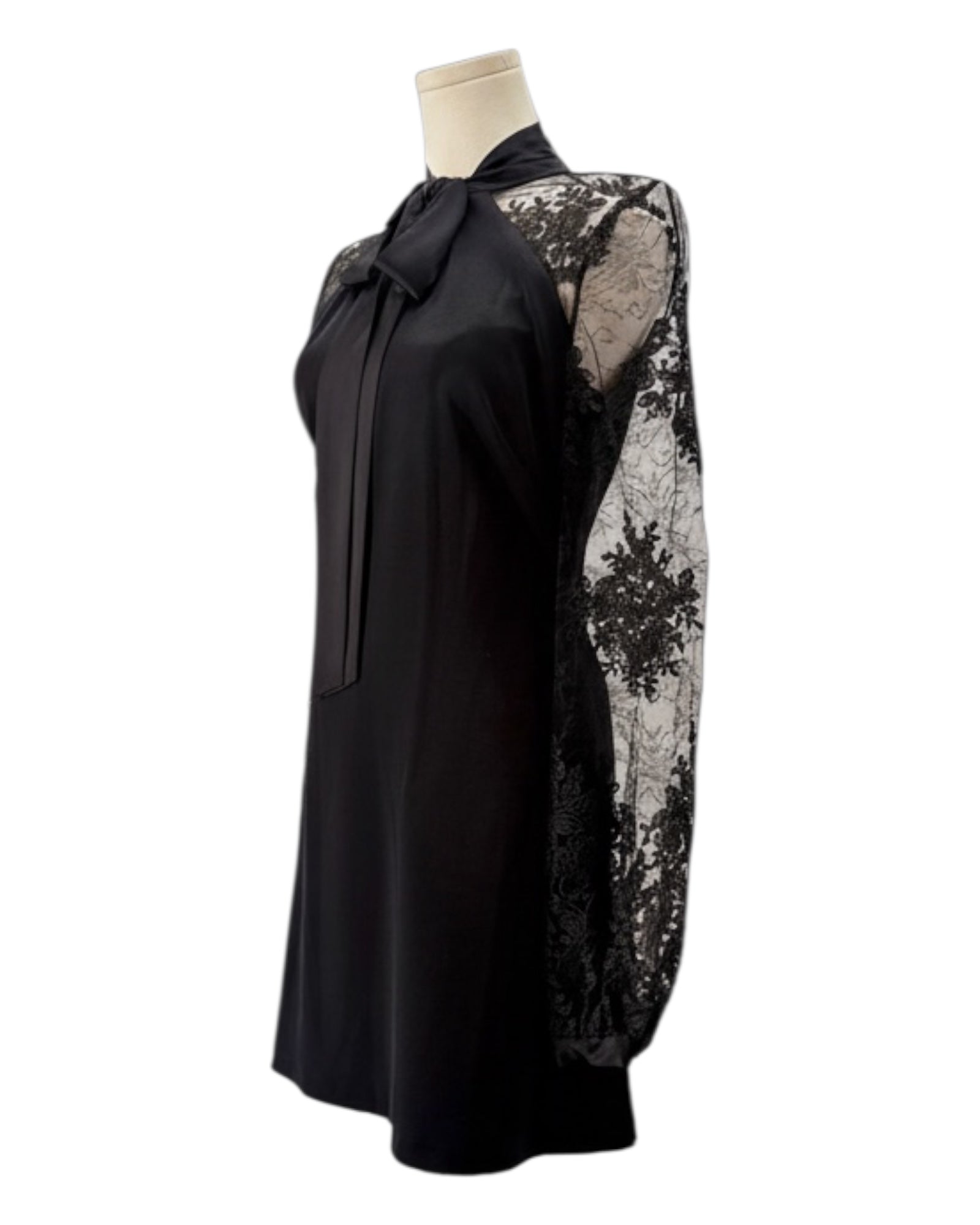 Black dress with lace detailing on a mannequin against a white background