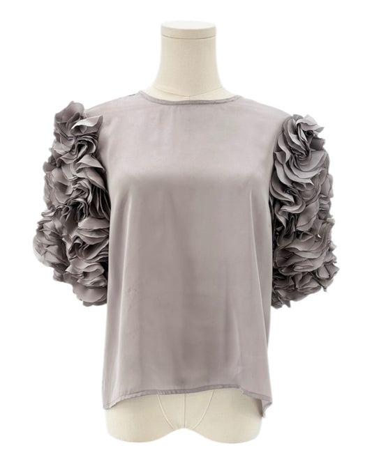 Gray top with floral sleeves on a mannequin against a white background