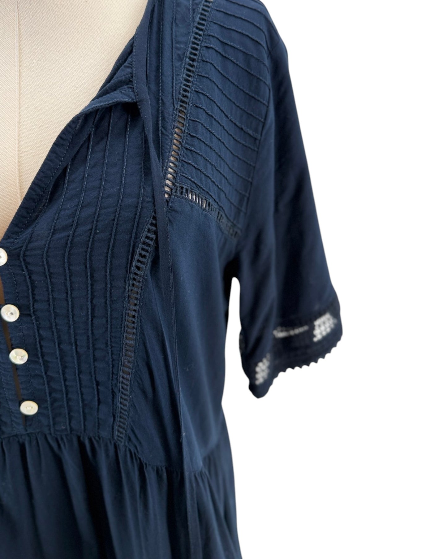 Navy blue dress with button details on a white background